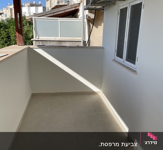 מרפסת עם רצפת אריחים וקיר לבן